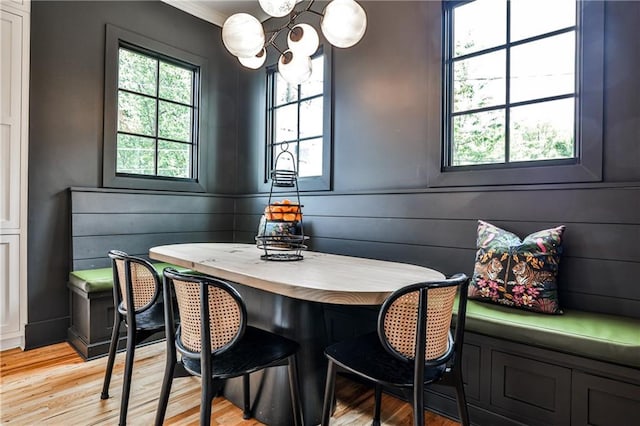 dining room featuring ornamental molding, light wood-style flooring, and a notable chandelier