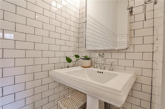 bathroom featuring tile walls and a sink