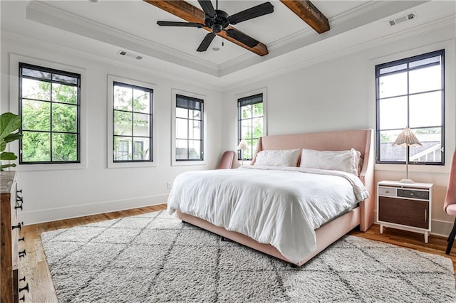 bedroom featuring crown molding, baseboards, visible vents, and wood finished floors