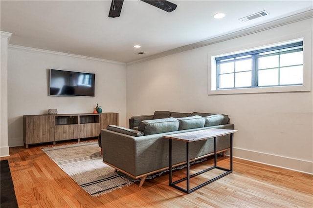 living room featuring ornamental molding, a ceiling fan, wood finished floors, and visible vents