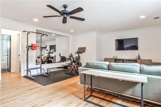 exercise area with visible vents, ornamental molding, and wood finished floors