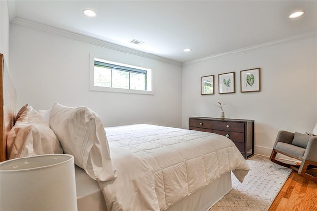 bedroom featuring light wood-style floors, ornamental molding, recessed lighting, and visible vents