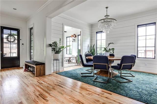 dining area with crown molding, wood finished floors, and a notable chandelier