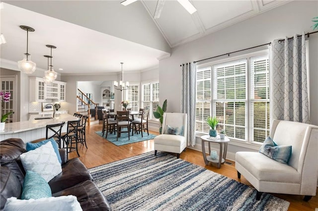 5173 Brendlynn Dr, Suwanee, GA 30024 - living room featuring ornamental molding, a chandelier, wood finished floors, vaulted ceiling, and baseboards