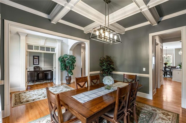 5173 Brendlynn Dr, Suwanee, GA 30024 - dining space with a chandelier, coffered ceiling, arched walkways, wood finished floors, and crown molding