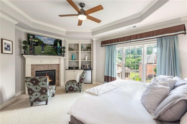 5173 Brendlynn Dr, Suwanee, GA 30024 - carpeted bedroom featuring crown molding, a tray ceiling, baseboards, a tile fireplace, and a ceiling fan