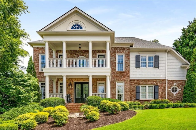 5173 Brendlynn Dr, Suwanee, GA 30024 - greek revival house with a balcony, covered porch, brick siding, french doors, and a front lawn