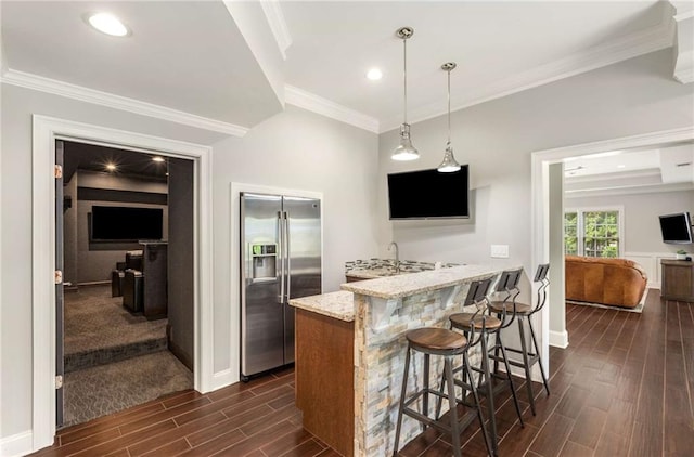 5173 Brendlynn Dr, Suwanee, GA 30024 - kitchen featuring stainless steel refrigerator with ice dispenser, wood tiled floors, a breakfast bar, baseboards, and crown molding