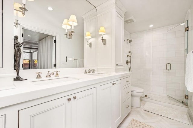 full bathroom featuring double vanity, a sink, toilet, and a shower stall