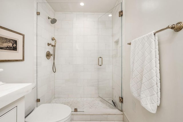 full bathroom featuring vanity, a shower stall, and toilet