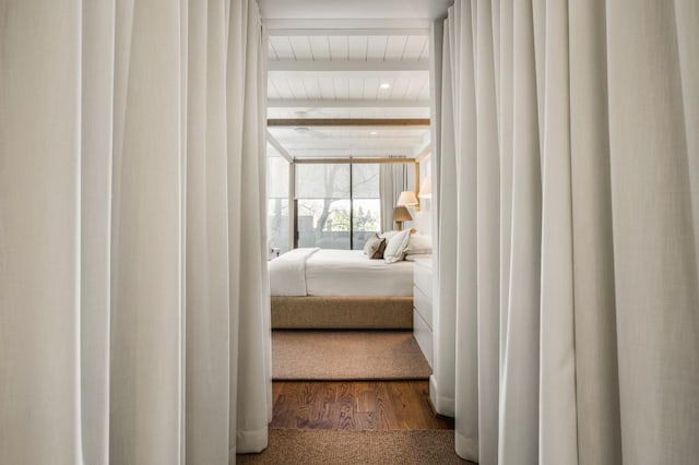 bedroom featuring beam ceiling and wood finished floors