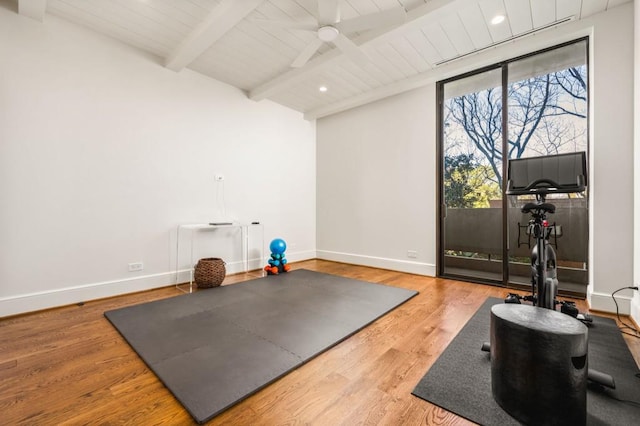 workout room with a ceiling fan, lofted ceiling, baseboards, and wood finished floors