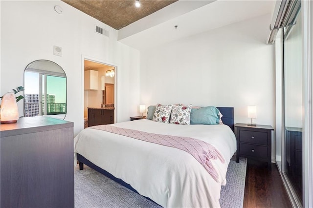 bedroom featuring visible vents and dark wood finished floors