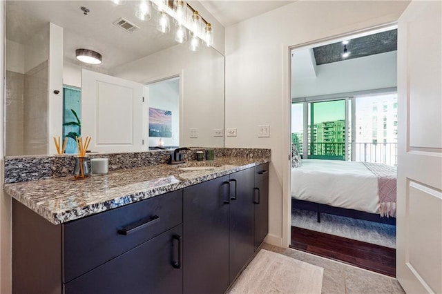 ensuite bathroom with tile patterned flooring, visible vents, connected bathroom, and vanity