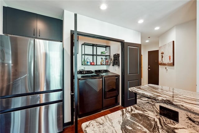 kitchen featuring light stone counters, recessed lighting, dark wood-style flooring, independent washer and dryer, and freestanding refrigerator