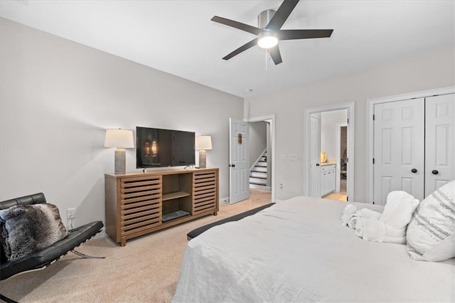 carpeted bedroom with ceiling fan, ensuite bathroom, and a closet