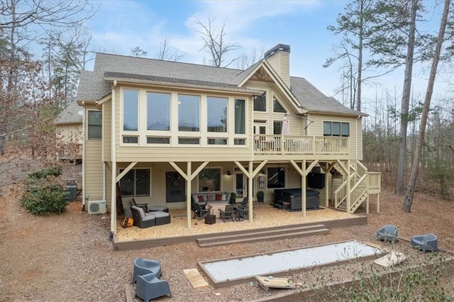 rear view of house featuring a patio area, a jacuzzi, a wooden deck, ac unit, and an outdoor living space