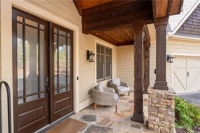 foyer entrance featuring crown molding, french doors, hardwood / wood-style floors, a notable chandelier, and lofted ceiling