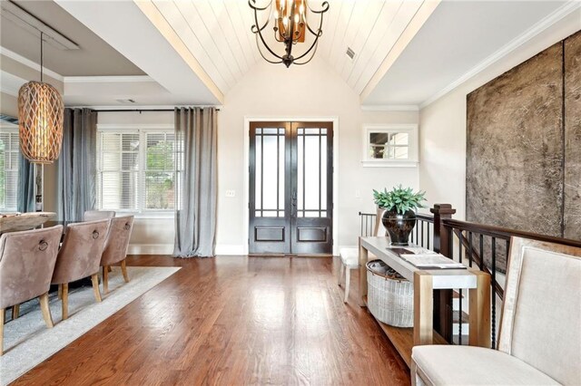 dining area with dark wood-type flooring, ornamental molding, and a raised ceiling