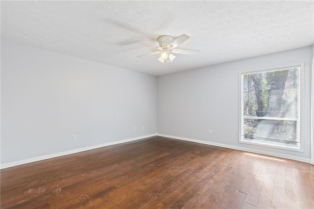 empty room with dark wood-style floors, a textured ceiling, baseboards, and a ceiling fan