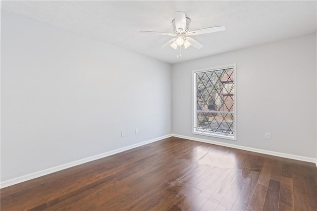 unfurnished room featuring a ceiling fan, dark wood-type flooring, and baseboards