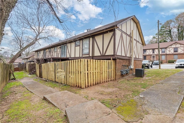 view of property exterior featuring central AC and fence