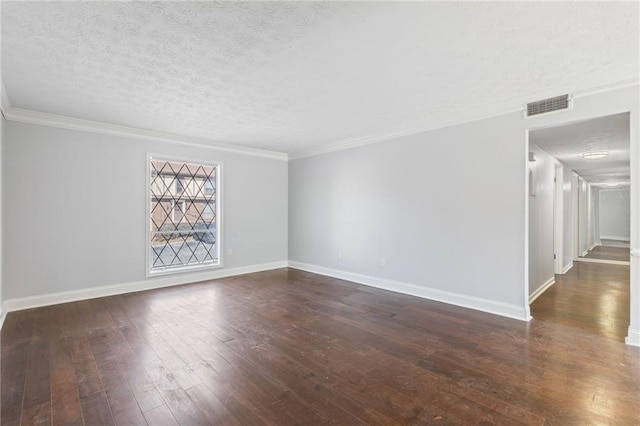 empty room with visible vents, a textured ceiling, hardwood / wood-style floors, crown molding, and baseboards