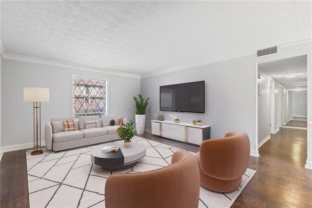 living area featuring visible vents, a textured ceiling, crown molding, and wood finished floors