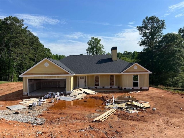 204 Nativity Cv, Winder, GA 30680 - property under construction featuring a chimney, an attached garage, board and batten siding, dirt driveway, and roof with shingles