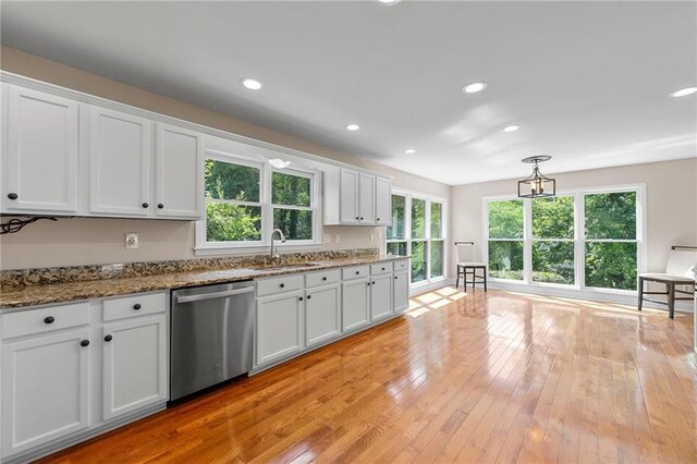 kitchen with stone counters, white cabinetry, dishwasher, sink, and light wood-type flooring