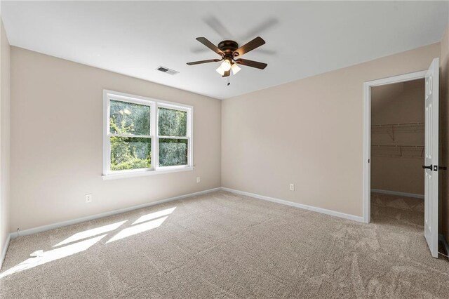 unfurnished room with light colored carpet and ceiling fan