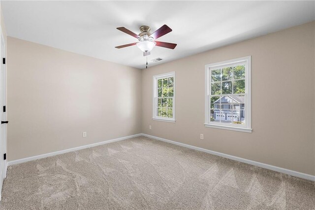 carpeted spare room featuring ceiling fan