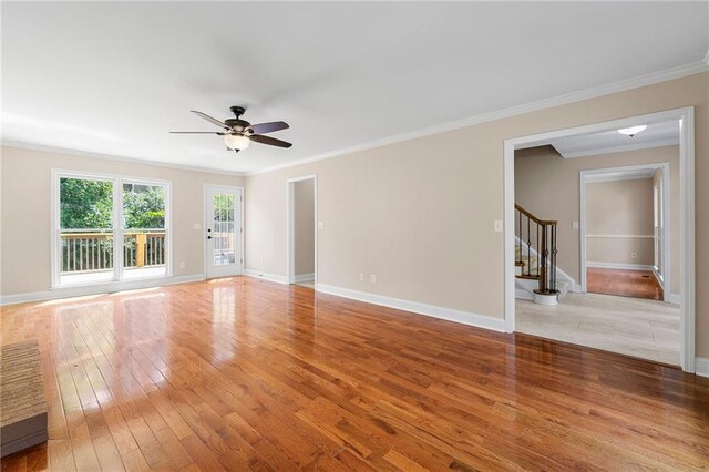 empty room featuring light wood-type flooring, ceiling fan, and crown molding