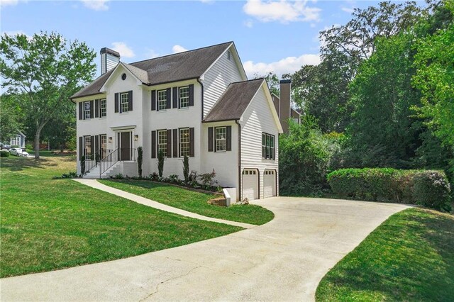 view of front of house with a garage and a front lawn