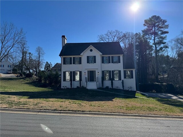 colonial home featuring a front lawn