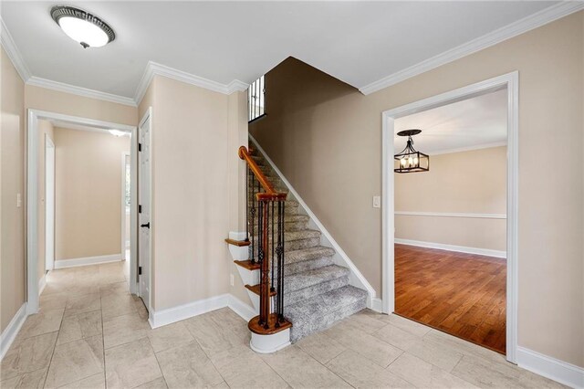 stairway with tile patterned flooring, a chandelier, and crown molding