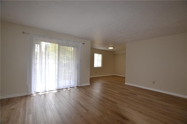 unfurnished room with dark hardwood / wood-style flooring