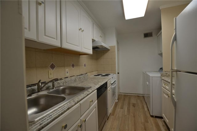 kitchen featuring sink, white refrigerator, dishwasher, washer and clothes dryer, and white cabinets