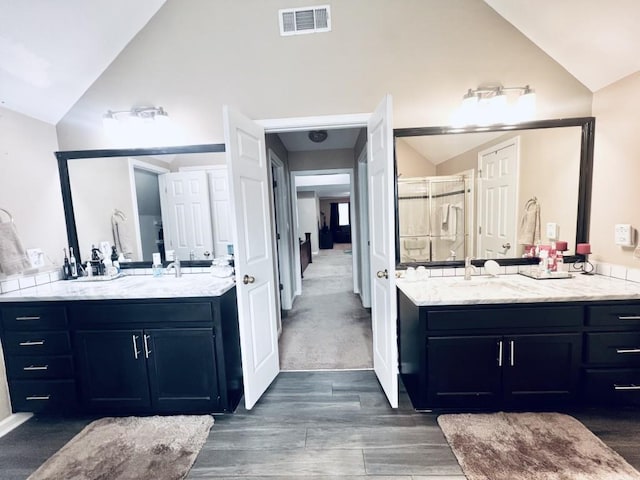 bathroom featuring vanity, a shower with shower door, hardwood / wood-style floors, and high vaulted ceiling