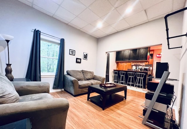 living room featuring hardwood / wood-style floors and a drop ceiling