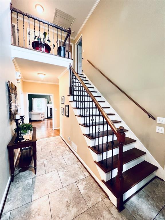 staircase featuring ornamental molding