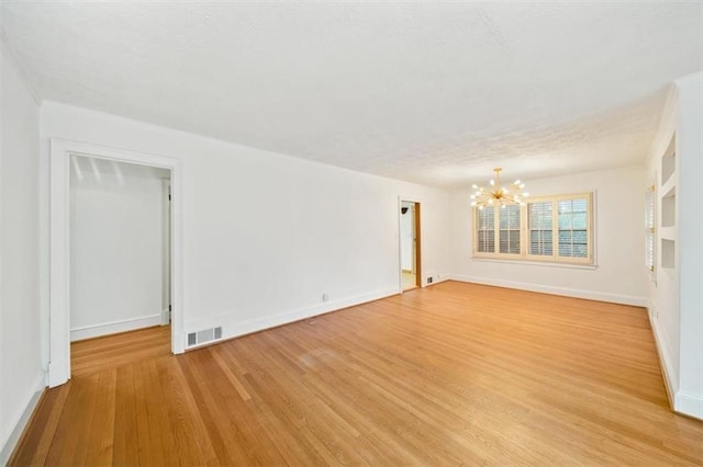 2044 Wilandrew Dr, Decatur, GA 30033 - unfurnished room with an inviting chandelier, light wood-type flooring, visible vents, and baseboards