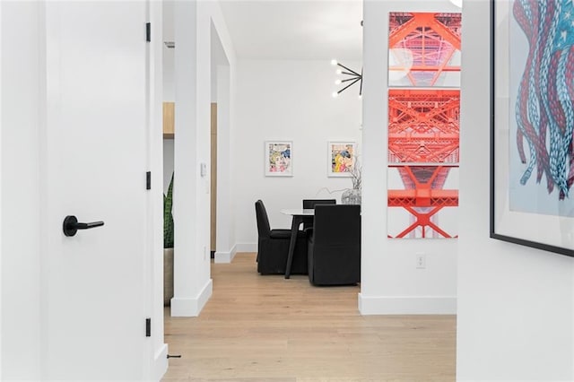 567 Ponce De Leon Ave NE Unit 614, Atlanta, GA 30308 - hallway with light wood-type flooring, baseboards, and a chandelier