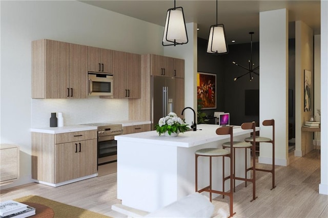 567 Ponce De Leon Ave NE Unit 614, Atlanta, GA 30308 - kitchen with stainless steel appliances, light wood finished floors, light countertops, a center island with sink, and a towering ceiling