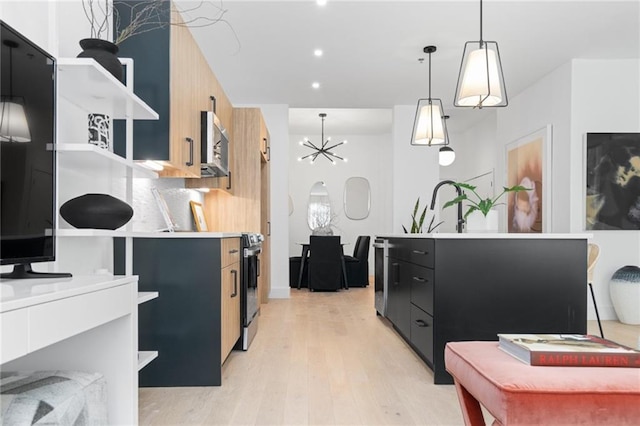 567 Ponce De Leon Ave NE Unit 614, Atlanta, GA 30308 - kitchen with dark cabinetry, stainless steel microwave, a chandelier, light wood-style floors, and modern cabinets