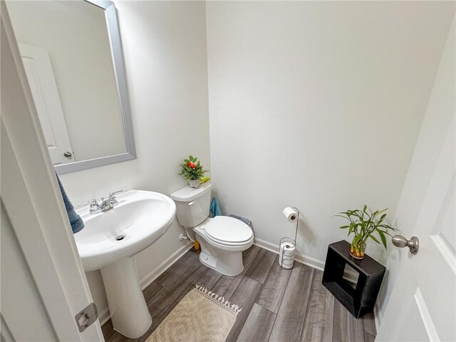 bathroom with sink, toilet, and hardwood / wood-style flooring