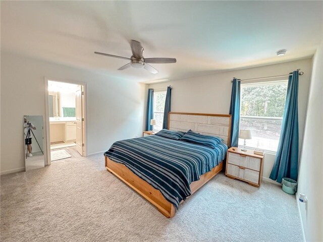 carpeted bedroom featuring connected bathroom, ceiling fan, and multiple windows