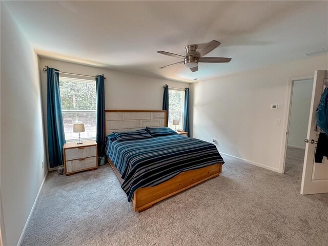 carpeted bedroom with multiple windows and ceiling fan