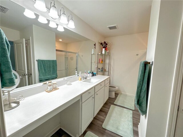 bathroom with vanity, toilet, wood-type flooring, and walk in shower