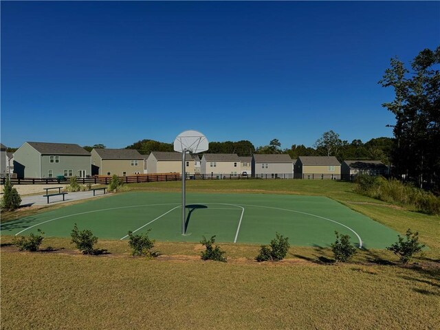 view of sport court with a lawn